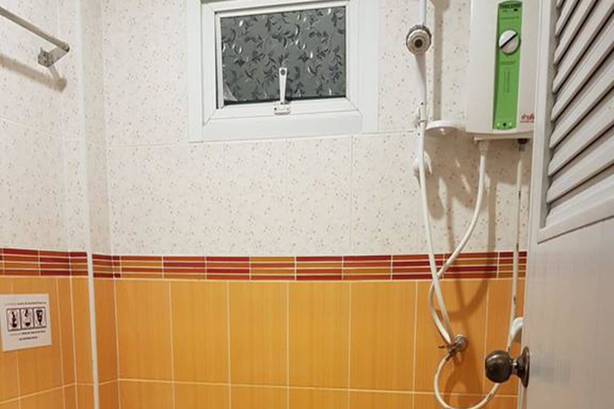 Une salle de bain avec des toilettes, une douche et une fenêtre.