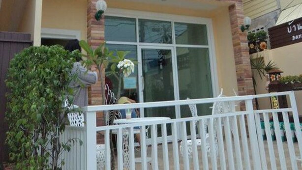 Un immeuble à plusieurs étages doté de balcons, d’une entrée sécurisée et de plantes en pot.