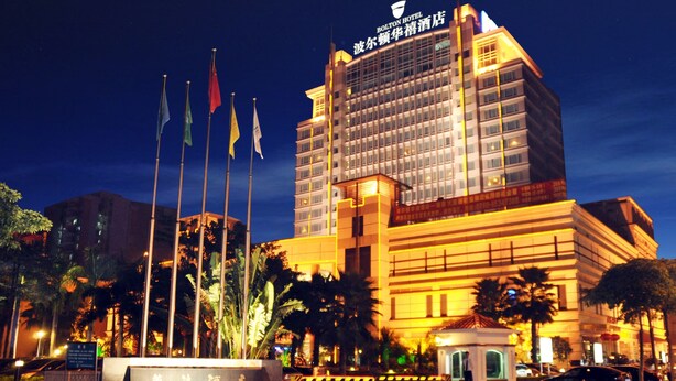 A hotel with multiple floors, a prominent entrance, and several flags. - Bolton Hotel Dongguan (Dongguan)