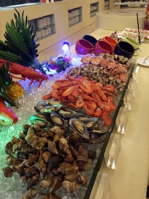 A seafood display with various types of shellfish and shrimp on ice. - Bolton Hotel Dongguan (Dongguan)