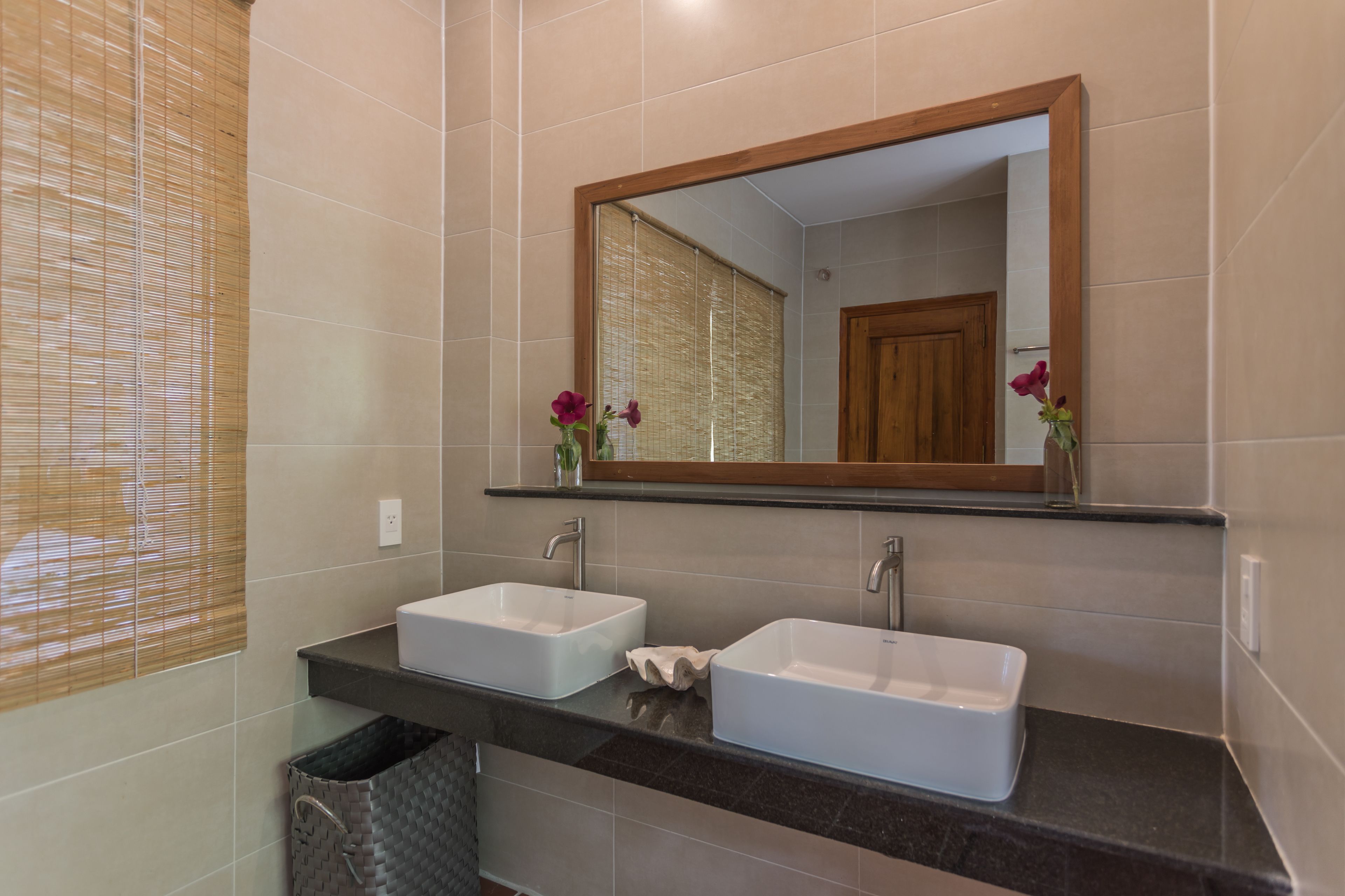 A bathroom with two white sinks, a mirror, and a towel rack.