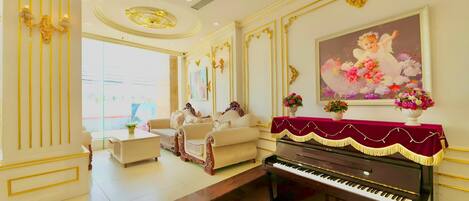 A grand living room with a piano, sofas, and a large painting.