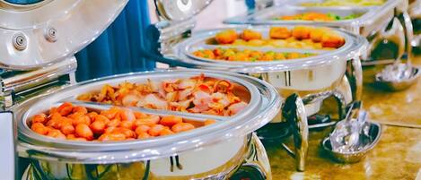 A buffet with various food items in metal serving dishes.