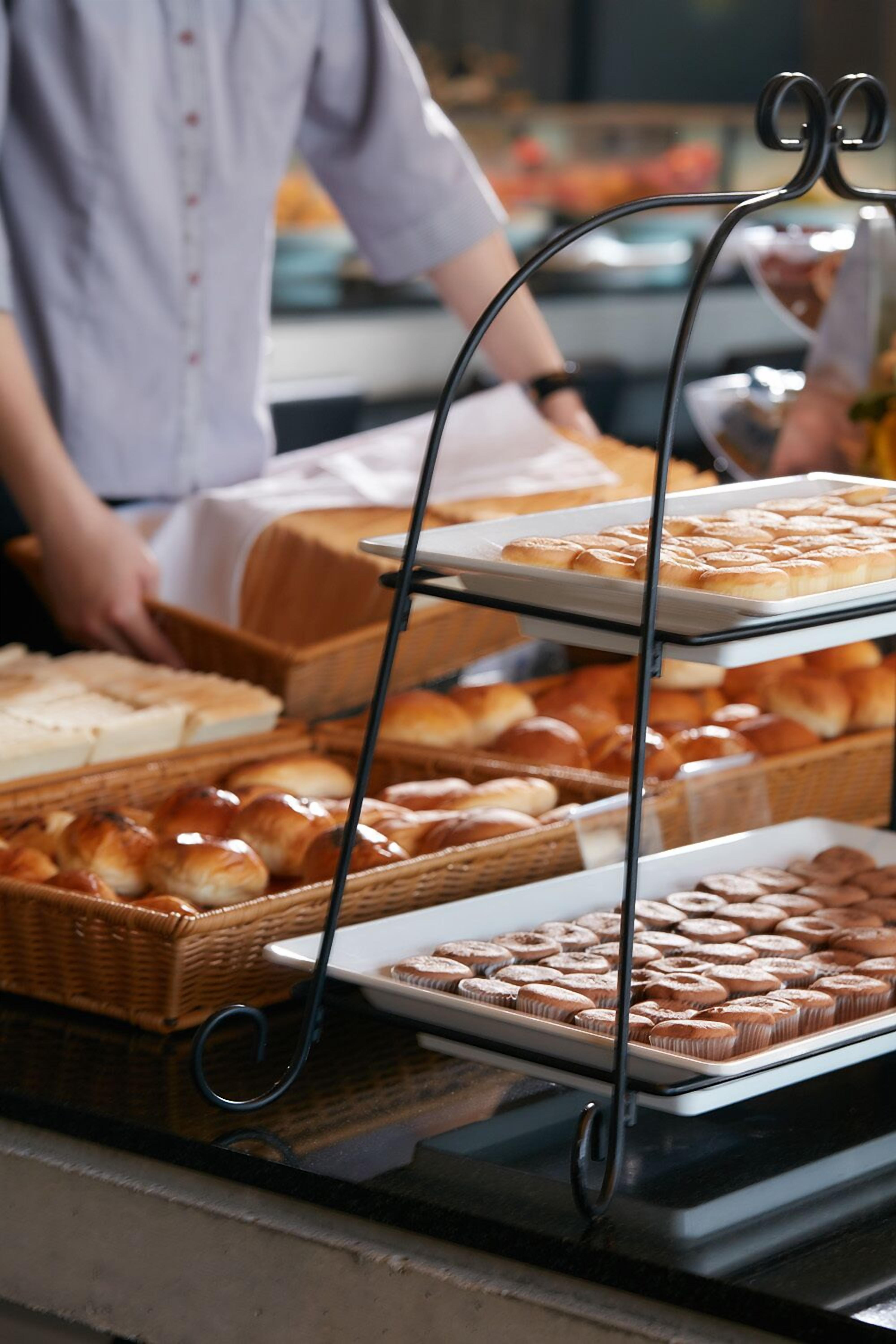 Un buffet con diversi prodotti da forno esposti su vassoi e cesti.