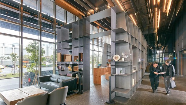 A modern interior with a seating area, a reception desk, and a view through large windows. - Orient Luxury Hotel (Chiayi City)