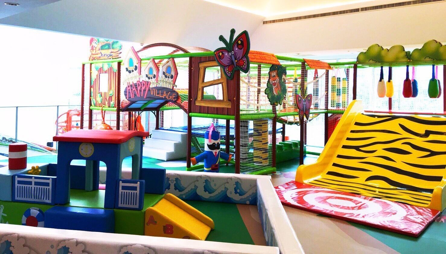 Un área de juegos infantiles con diversas estructuras, incluyendo un tobogán y una red de escalada.