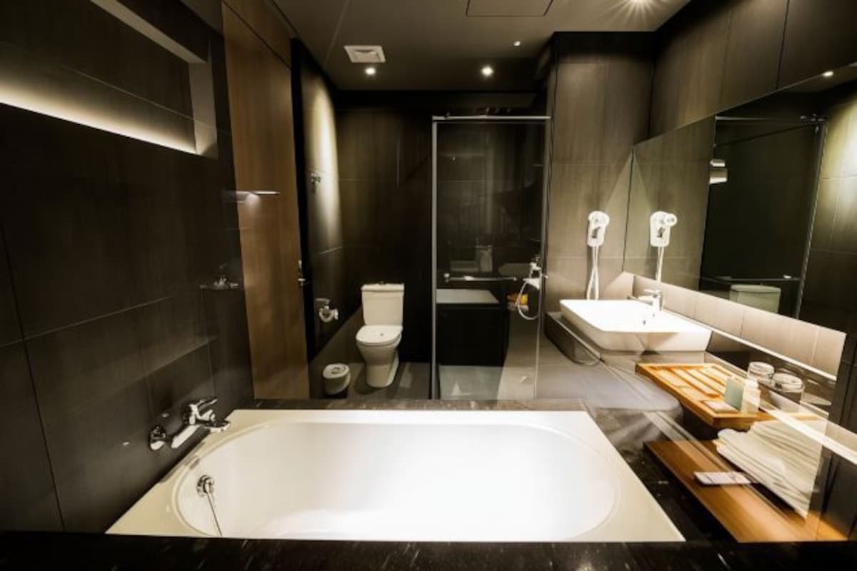 Un baño moderno con una bañera grande, zona de ducha separada y tocador con espejo.