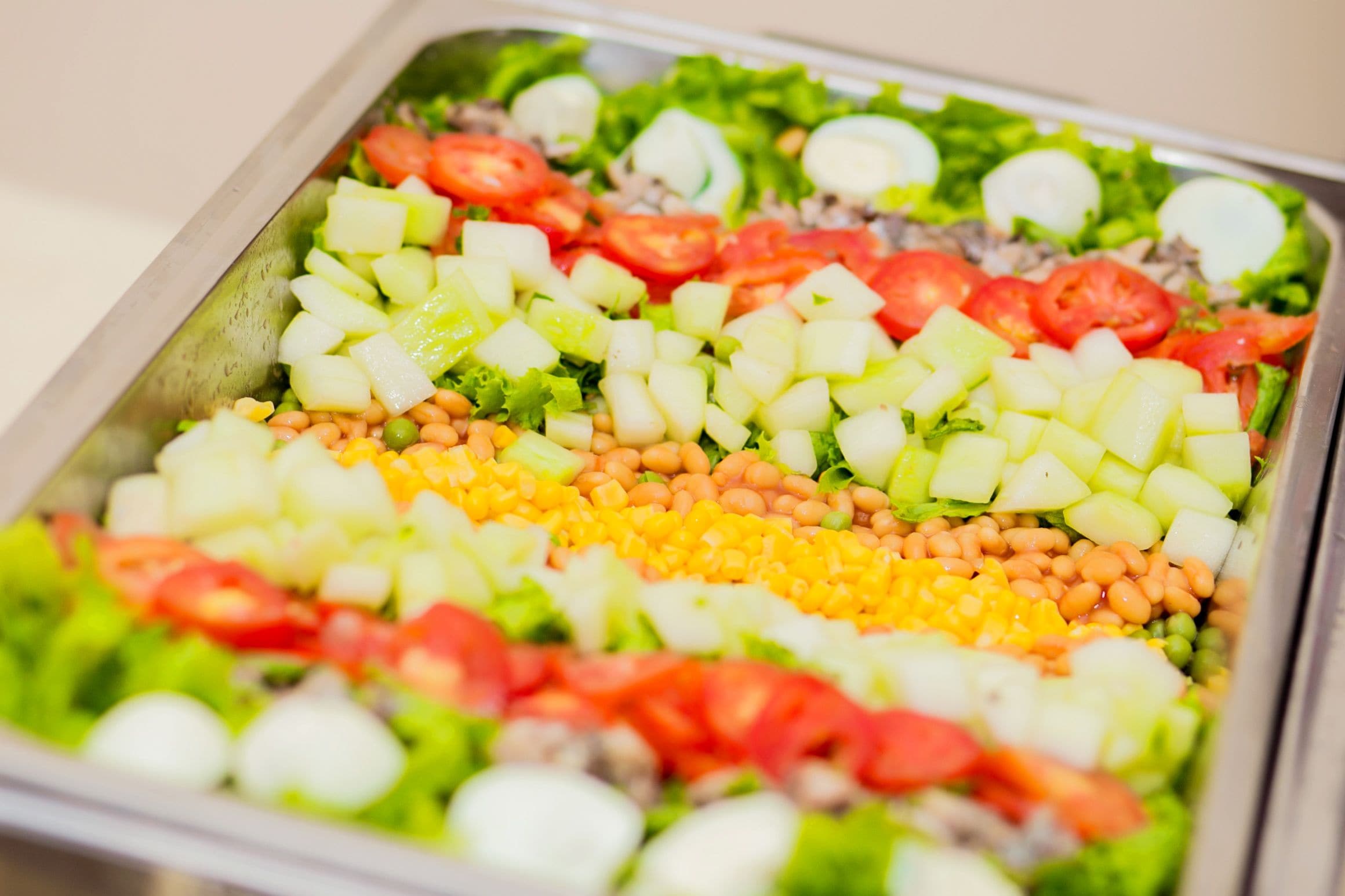 A salad tray with various vegetables and fruits.
