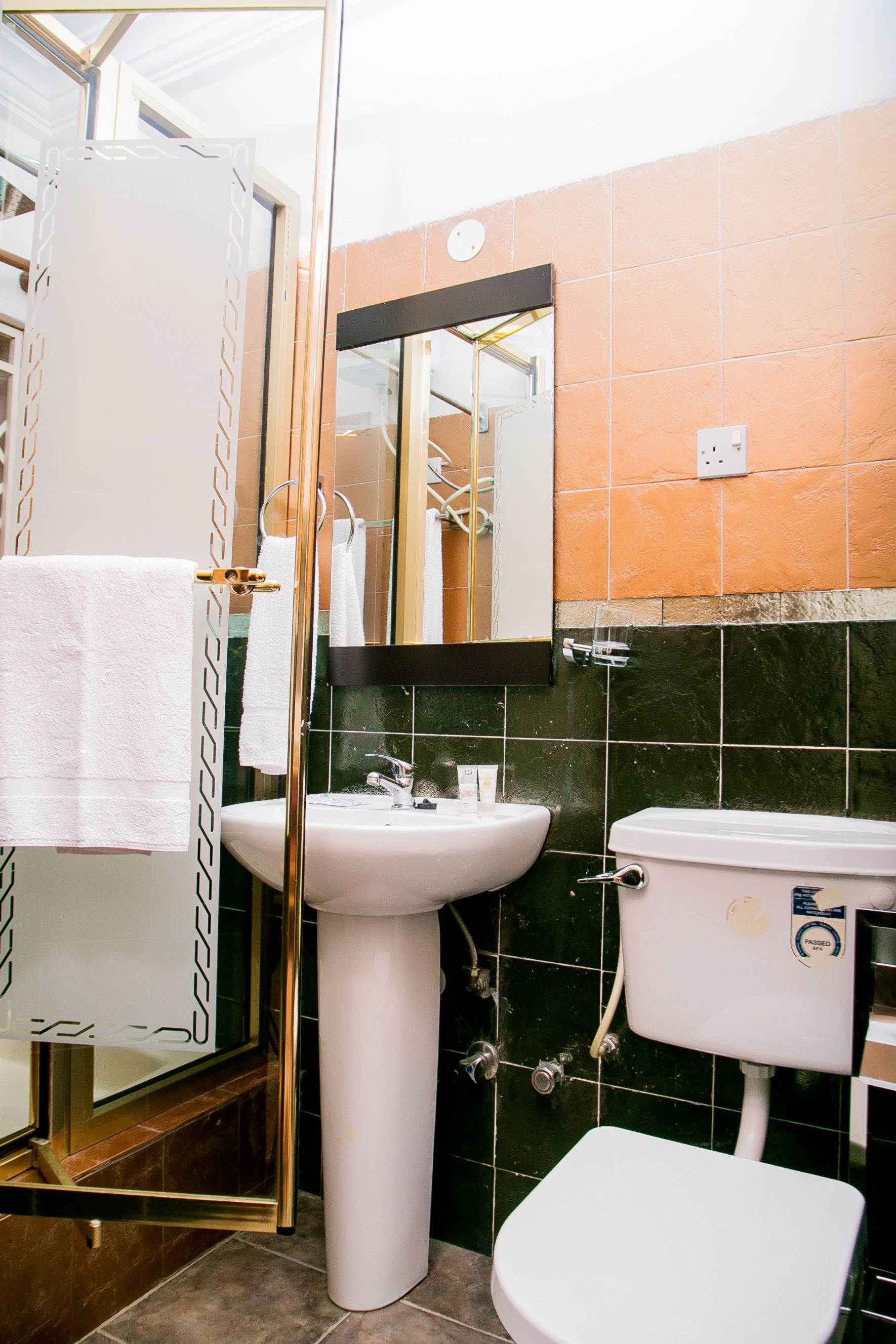 Un baño con un lavabo blanco, un inodoro blanco y una cabina de ducha de cristal.