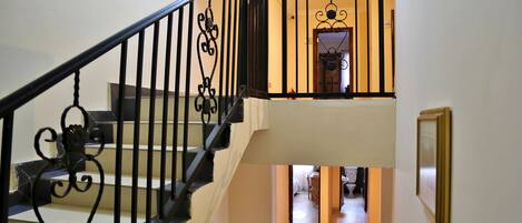 A staircase with ornate black railings leading to a second-floor landing.