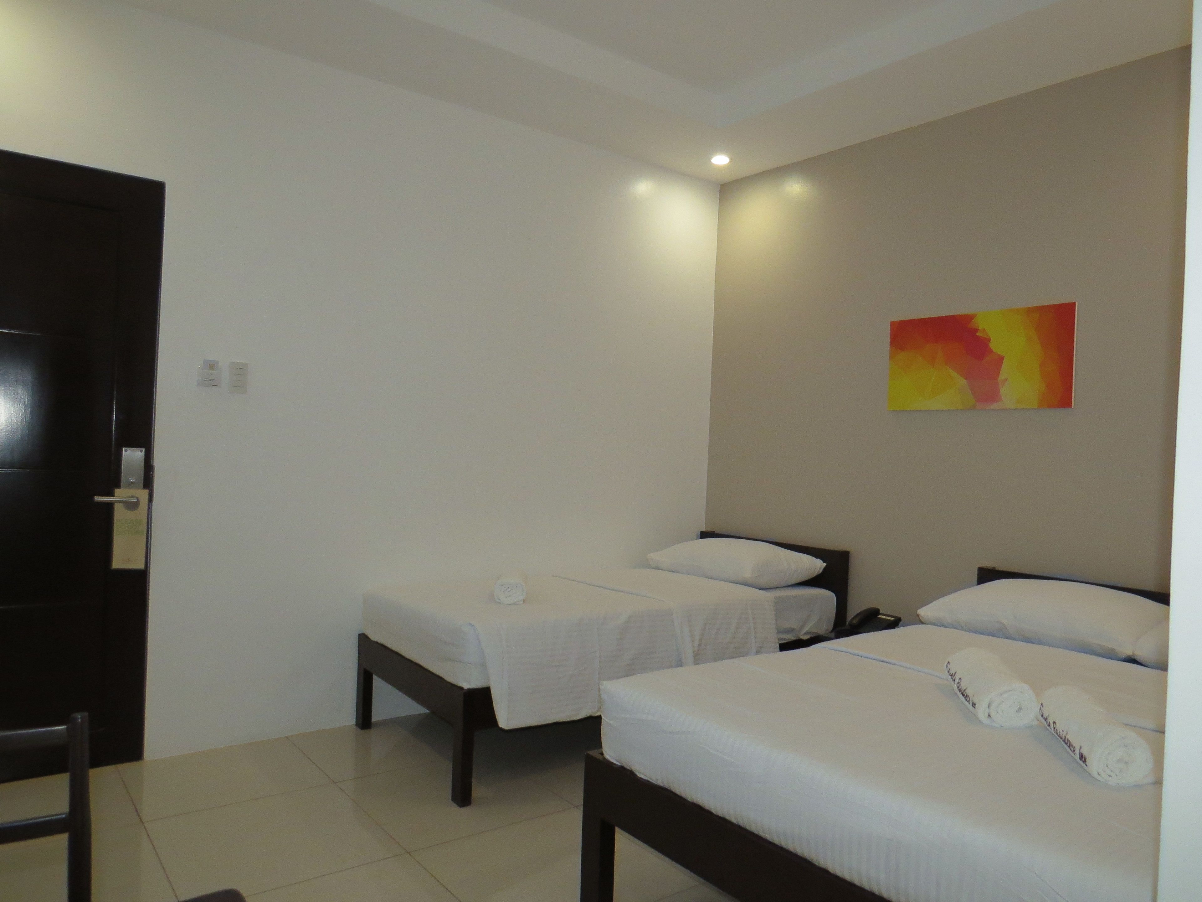 Une chambre d’hôtel avec deux lits simples, un bureau et une chaise.