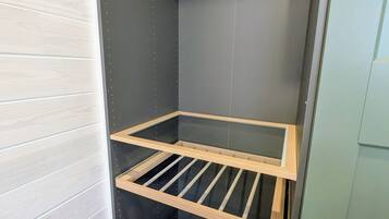 Une pièce dotée d’une bibliothèque intégrée en bois, d’un banc et d’un luminaire fixé au plafond.