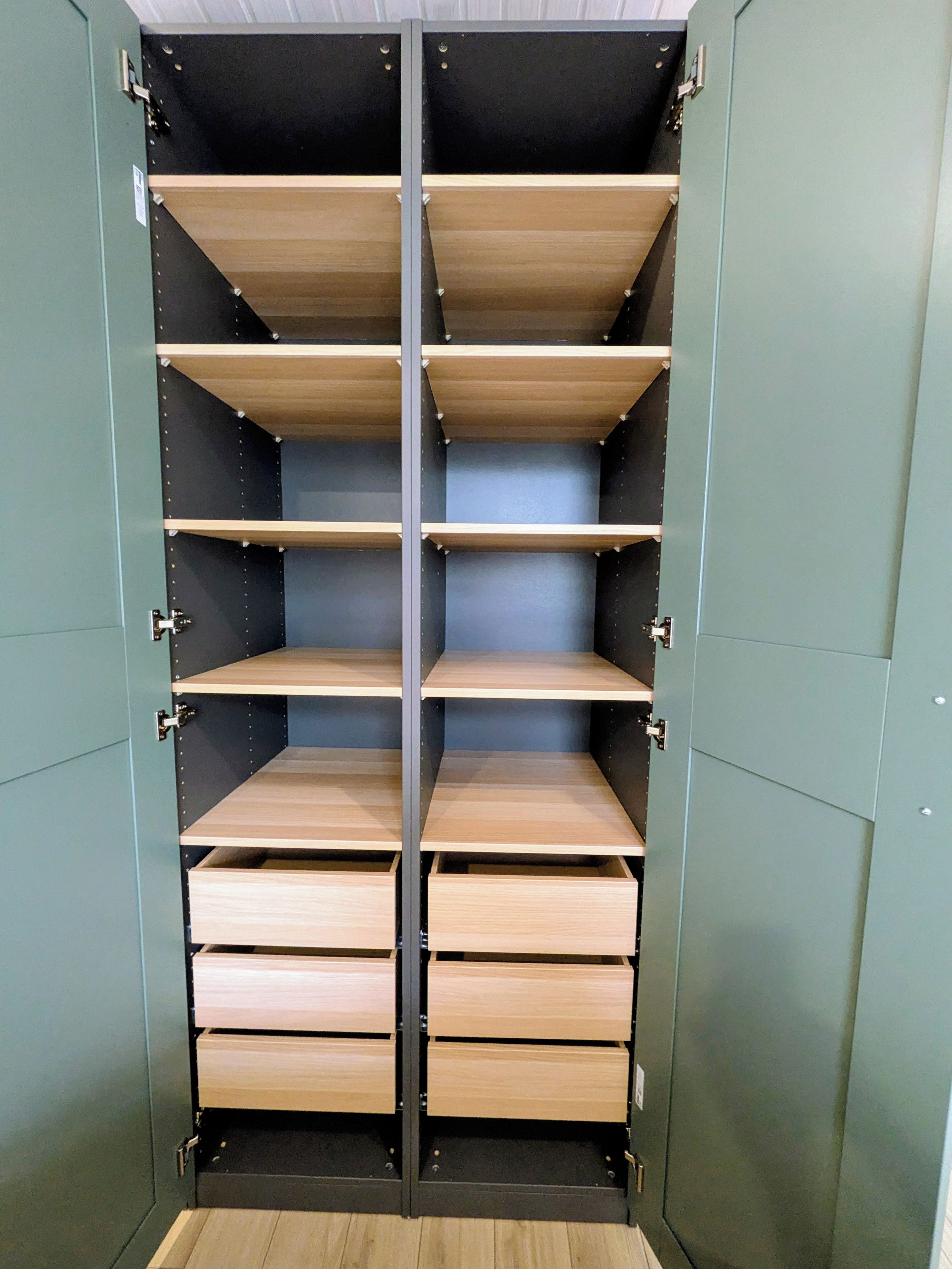 A metal wardrobe with multiple shelves and drawers.
