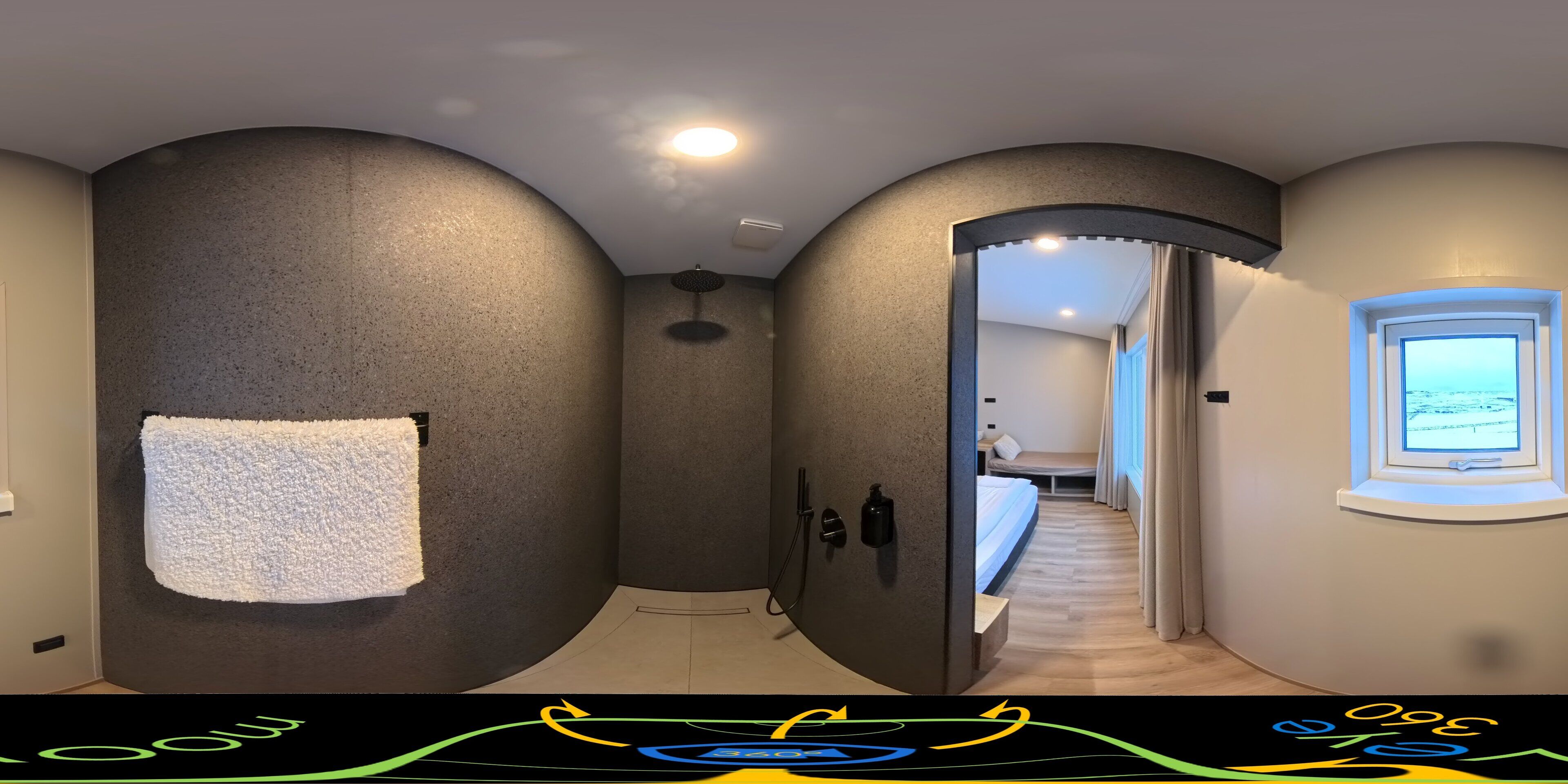 A hallway with a curved wall, a towel hanging on the left, a shower area, and a bed with a view of the sky through a window.