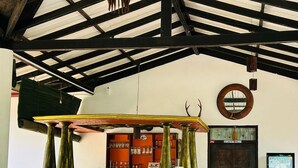 A bar area with a rustic wooden counter, stools, and large vases. - Traumvilla Bentota (Bentota)