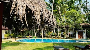 Una piscina al aire libre, camas de piscina gratis, sombrillas