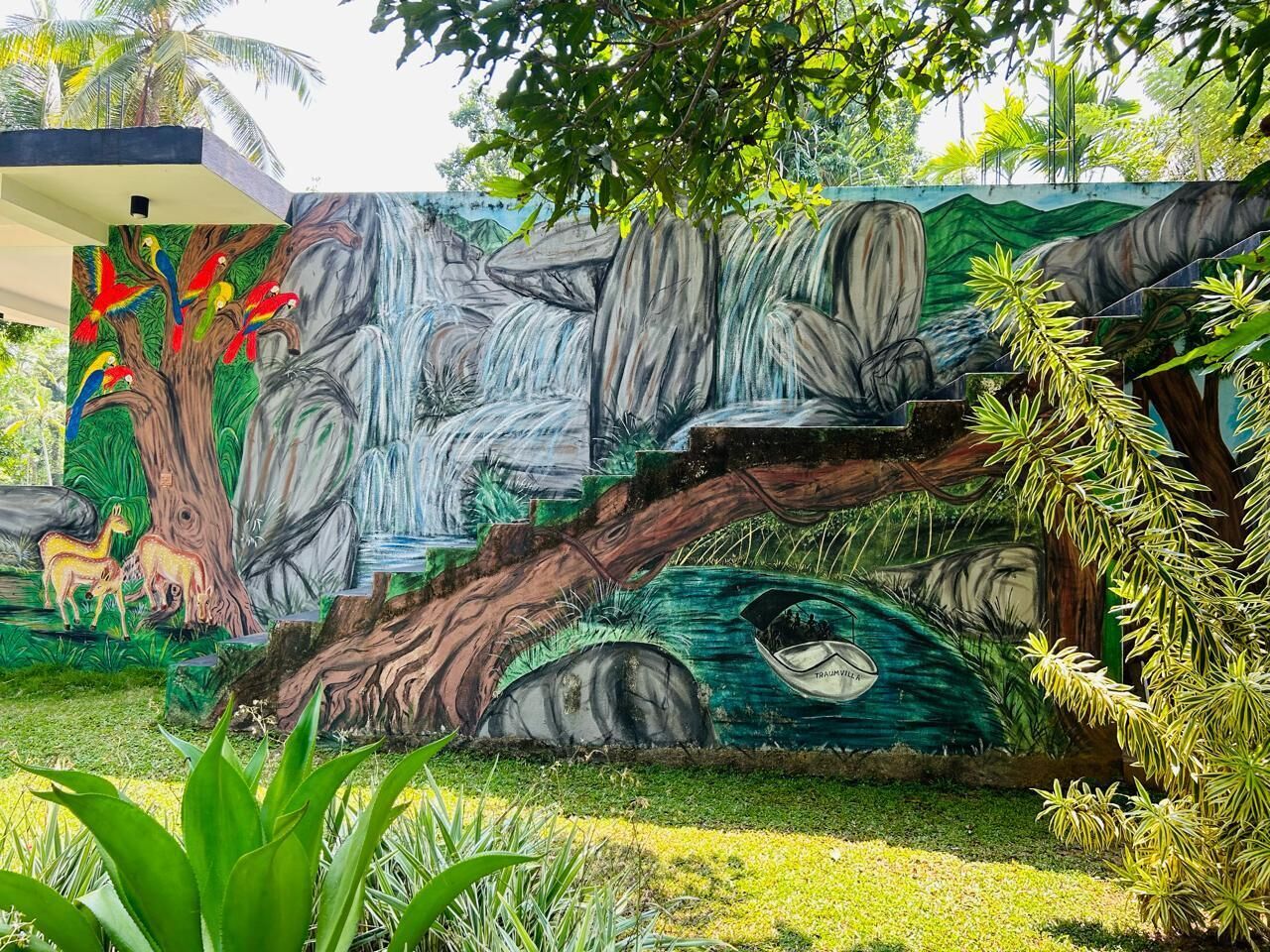 A mural of a waterfall and animals, a tree, and a boat labeled "TRIUMPH."