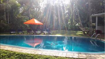Una piscina al aire libre, camas de piscina gratis, sombrillas