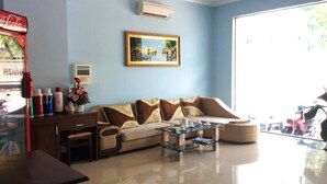 A modern living room with a sofa, coffee table, and a framed picture on the wall. - Huy Hoang Hotel (Phu Quoc)