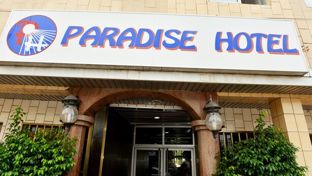 A sign for Paradise Hotel with a logo and the name in large letters. - Paradise Hotel (Lomé)