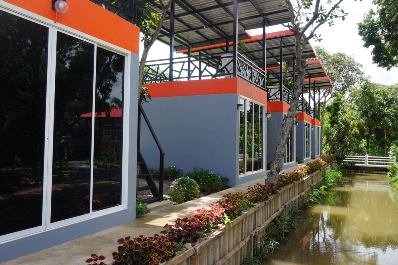 A modern building with large windows, a covered walkway, and a water channel.