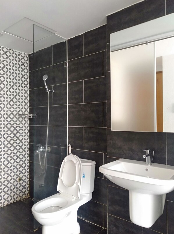 Un baño moderno con inodoro, lavamanos y ducha.