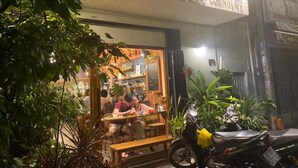 A Cokerut Cafe with outdoor seating and a motorcycle parked outside.
