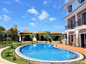 Una piscina al aire libre, sillones reclinables de piscina