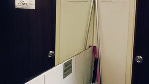 Ein Badezimmer mit zwei Waschbecken, einem Spiegel und einer Tür mit Schild, das auf Energiesparung hinweist.