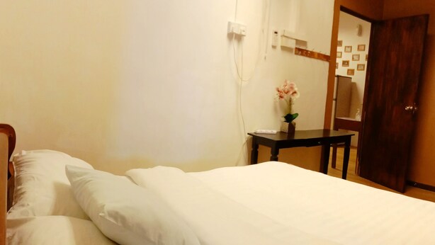 Ein ordentlich bezogenes Bett mit weißen Leinen in einem Hotelzimmer.