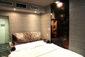A hotel room with a bed, a headboard, a wall-mounted poster, and a door. - Cinema Hotel UIBE (Beijing)