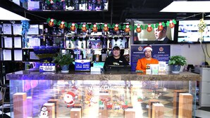 A reception area with a counter, two staff members, festive decorations, and a Christmas-themed display. - Cinema Hotel UIBE (Beijing)