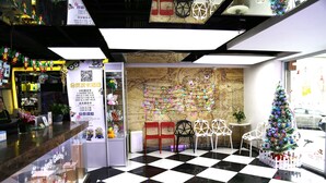A lobby with a checkered floor, a Christmas tree, and a map on the wall. - Cinema Hotel UIBE (Beijing)