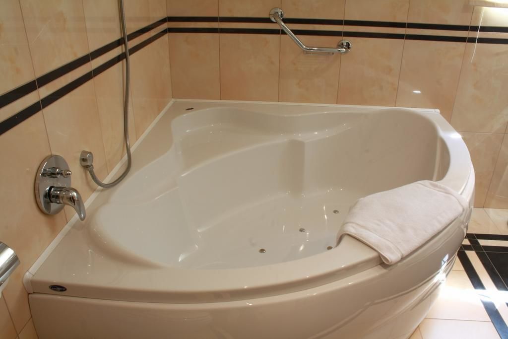 Ein modernes Badezimmer mit einer freistehenden Badewanne, einer Handbrause und einem Handtuchhalter.