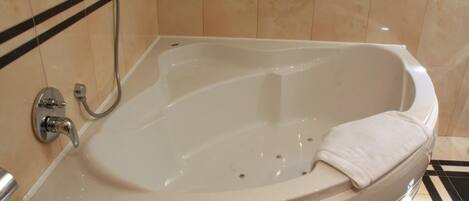 Ein modernes Badezimmer mit einer freistehenden Badewanne, einer Handbrause und einem Handtuchhalter.