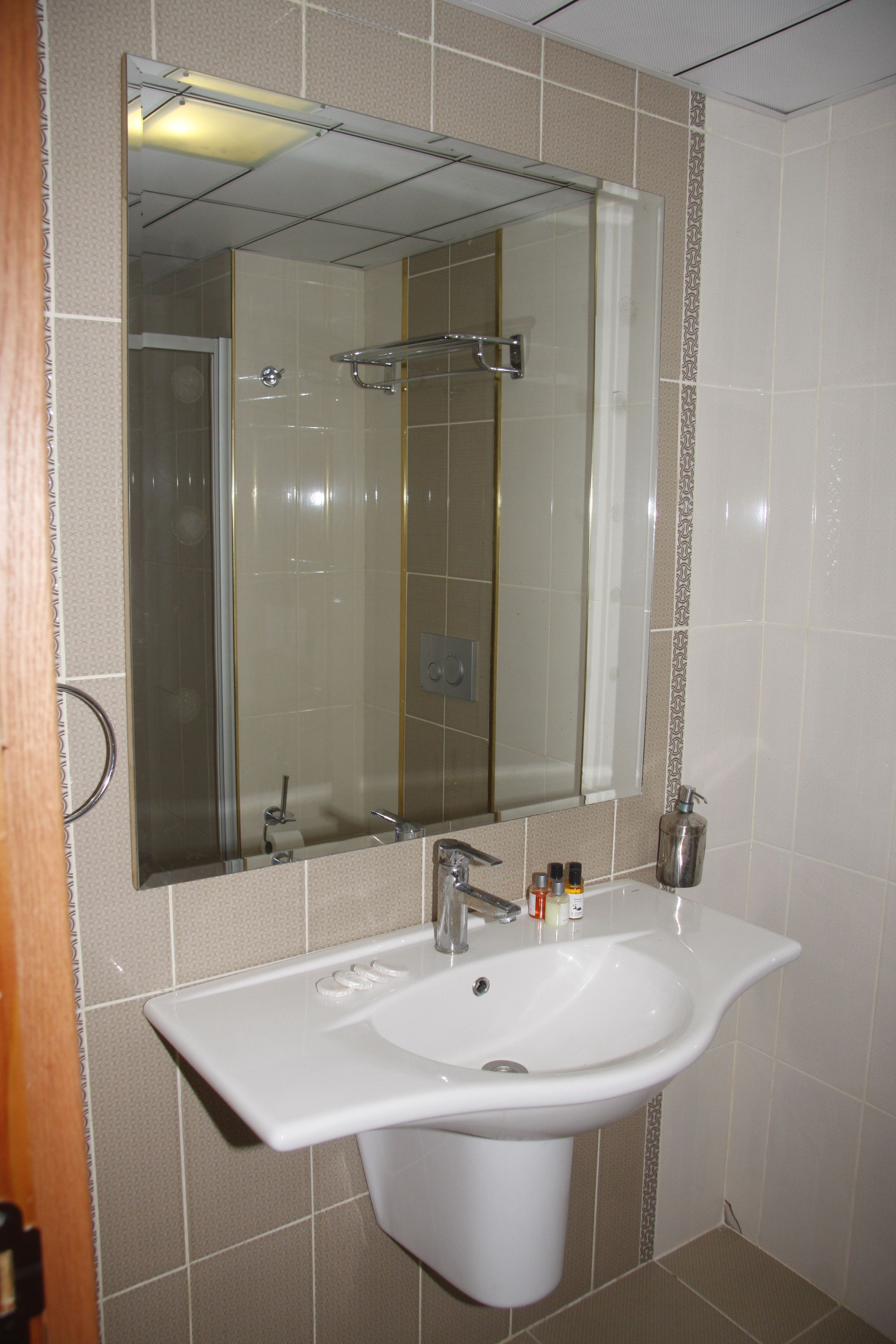 A bathroom with a white sink, a mirror, and a shower.
