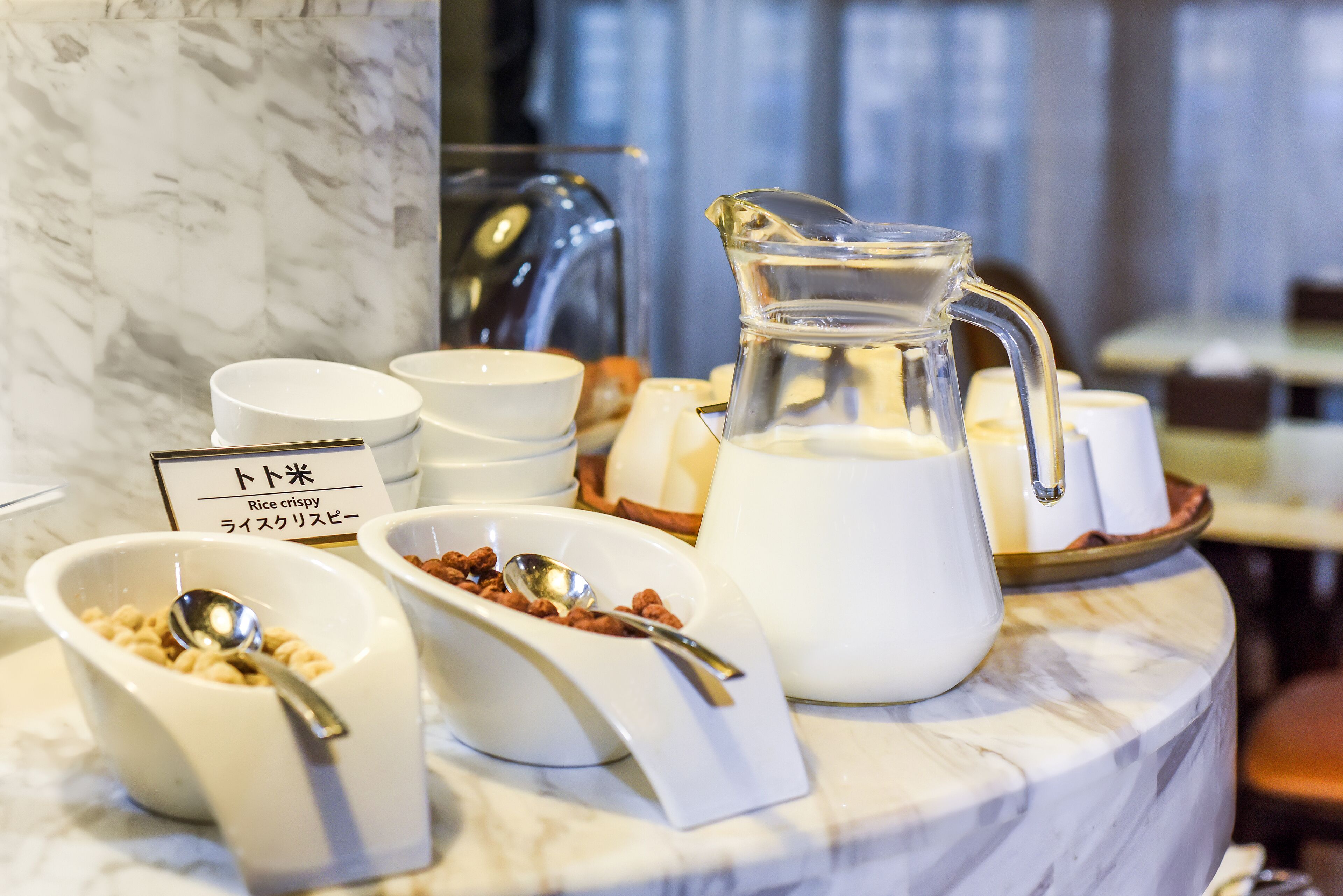 A breakfast buffet with various dishes and a sign indicating 'Rice crispy'.