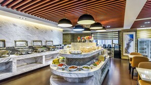 A buffet area with marble countertops, multiple serving stations, and overhead lighting. - JINGDUHUI Hotel (Dongguan)
