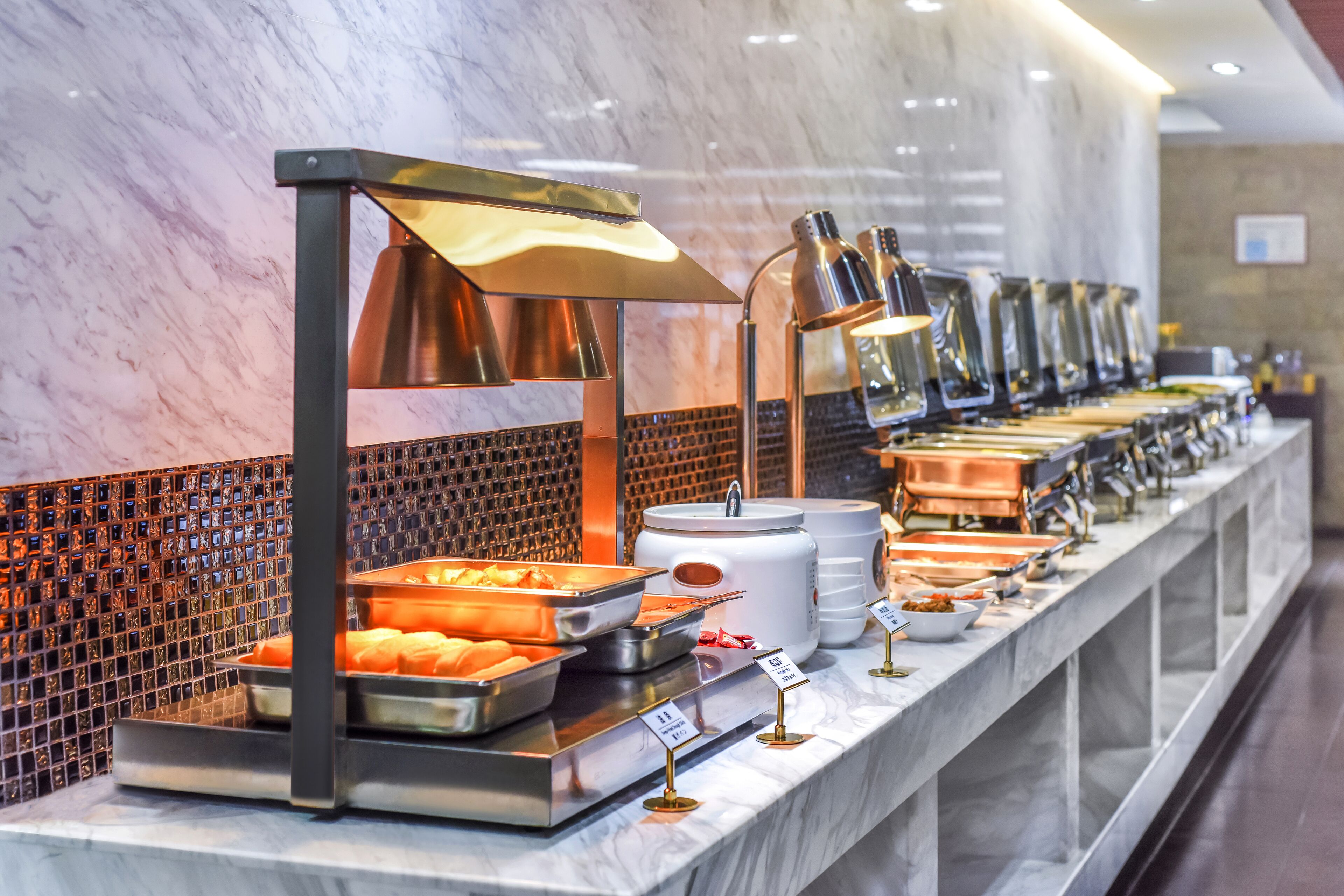 A buffet setup with various food items and a marble counter.
