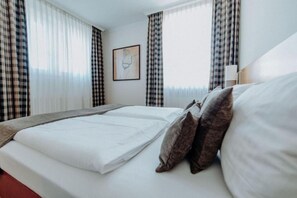 Ropa de cama de alta calidad y caja de seguridad en la habitación 