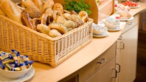 A buffet setup with various food items, including bread, cheese, and vegetables. - Hotel Ars Vivendi München (Munich)