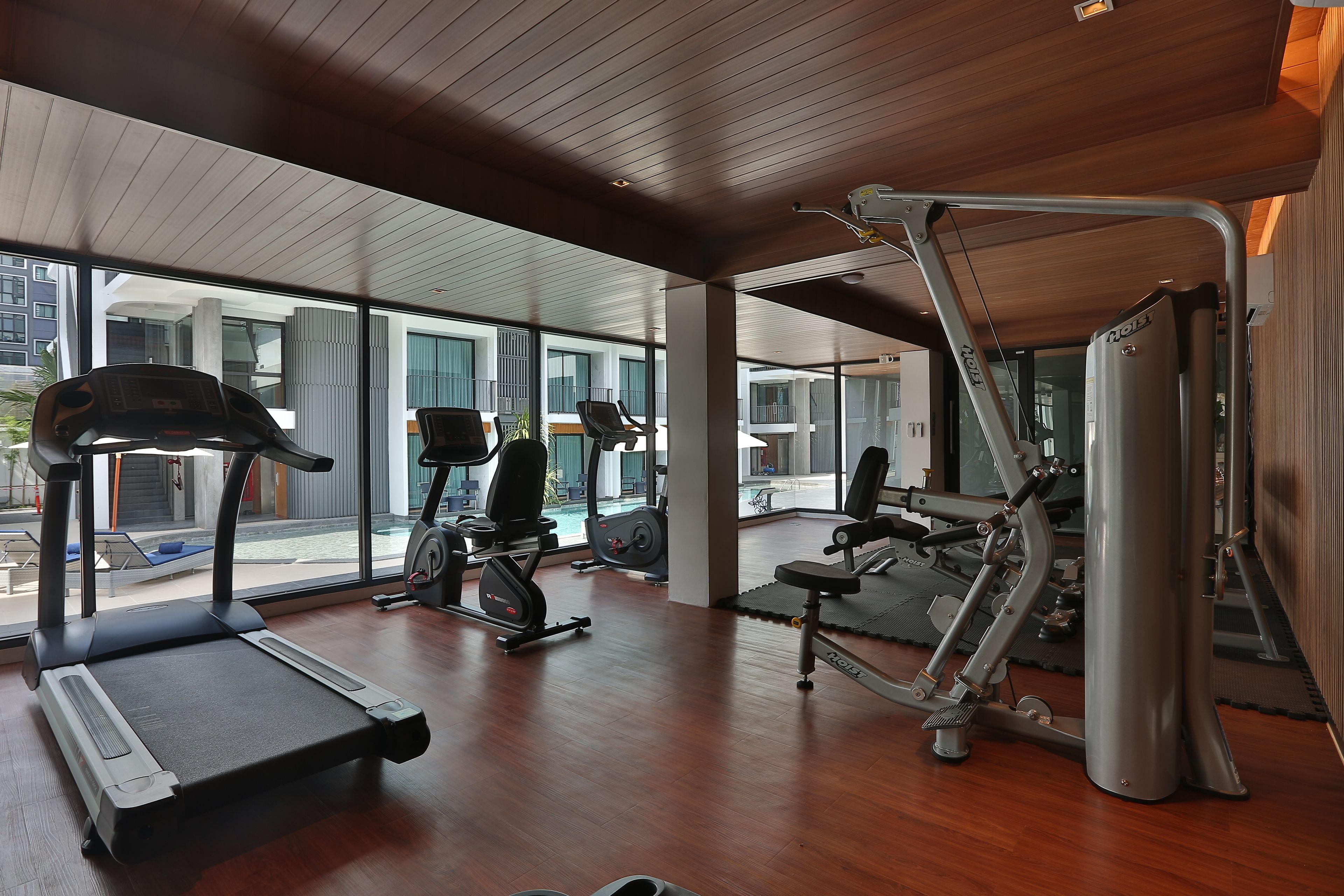 Un gimnasio con cintas de correr, elípticas y máquinas de pesas.