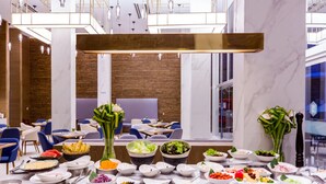 A buffet setup with various dishes and a modern interior design. - Wintree City Resort Chiang Mai (Chiang Mai)