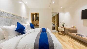 Una habitación de hotel moderna con una cama grande, un escritorio y una zona de estar.