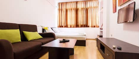 Departamento Confort, 1 habitación, para no fumadores, vista a la ciudad | Área de sala de estar | Televisión de pantalla plana y películas con cargo