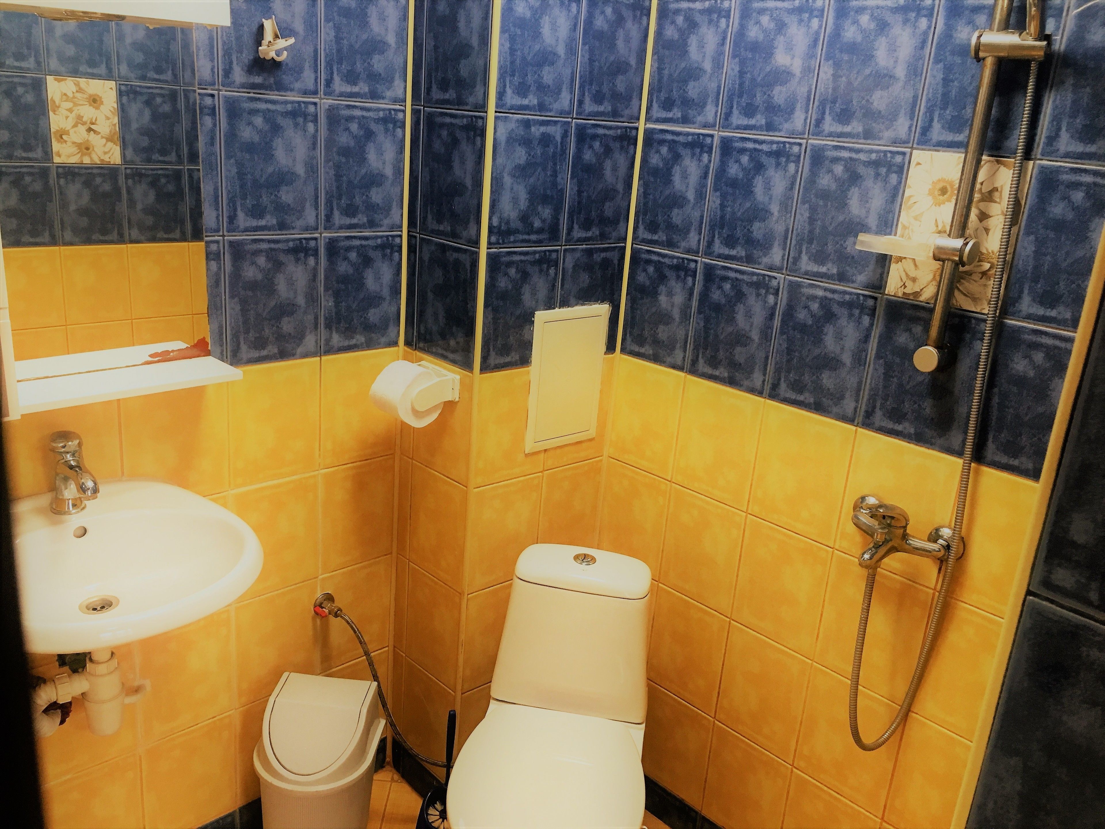 A small bathroom with a toilet, sink, and shower.