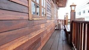 A wooden exterior with a balcony, railings, and windows.