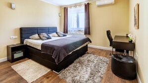 A bedroom with a bed, bedside table, desk, chair, and a bag. - Stay Split Bay (Kastela)