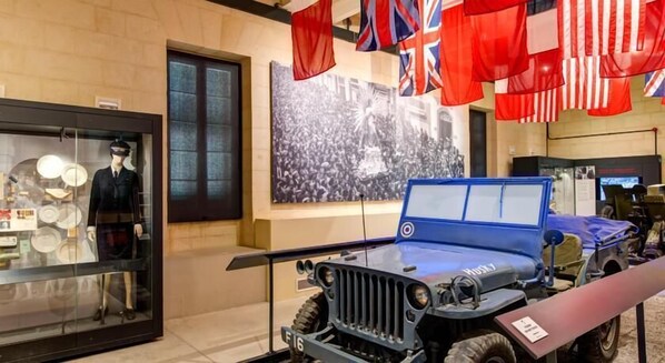 A museum exhibit featuring a military vehicle and a mannequin in uniform.