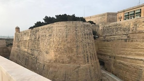 Un amplio muro de piedra con un estrecho pasaje.